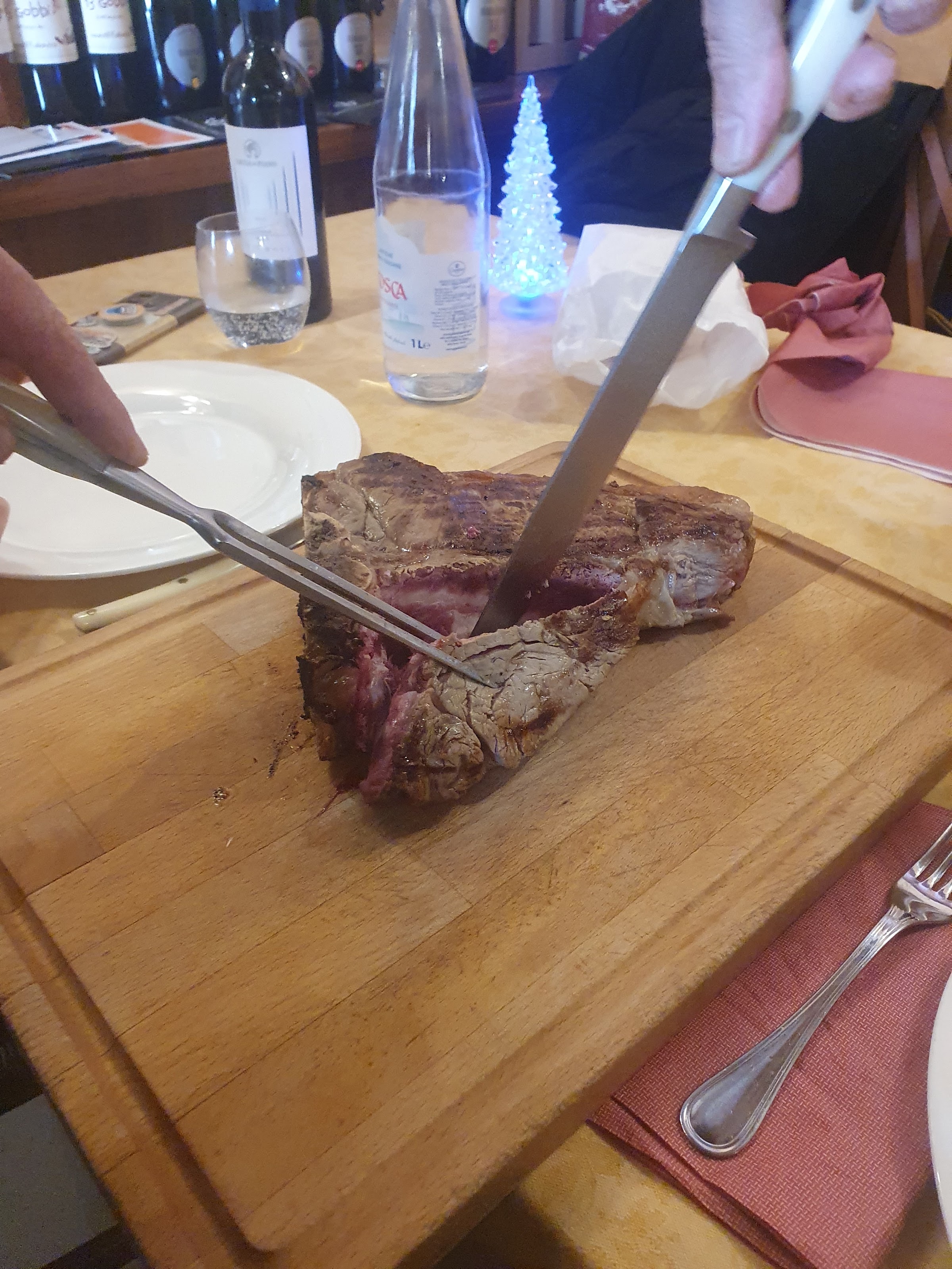 La bistecca alla fiorentina alla brace, tagliata al momento sul tagliere